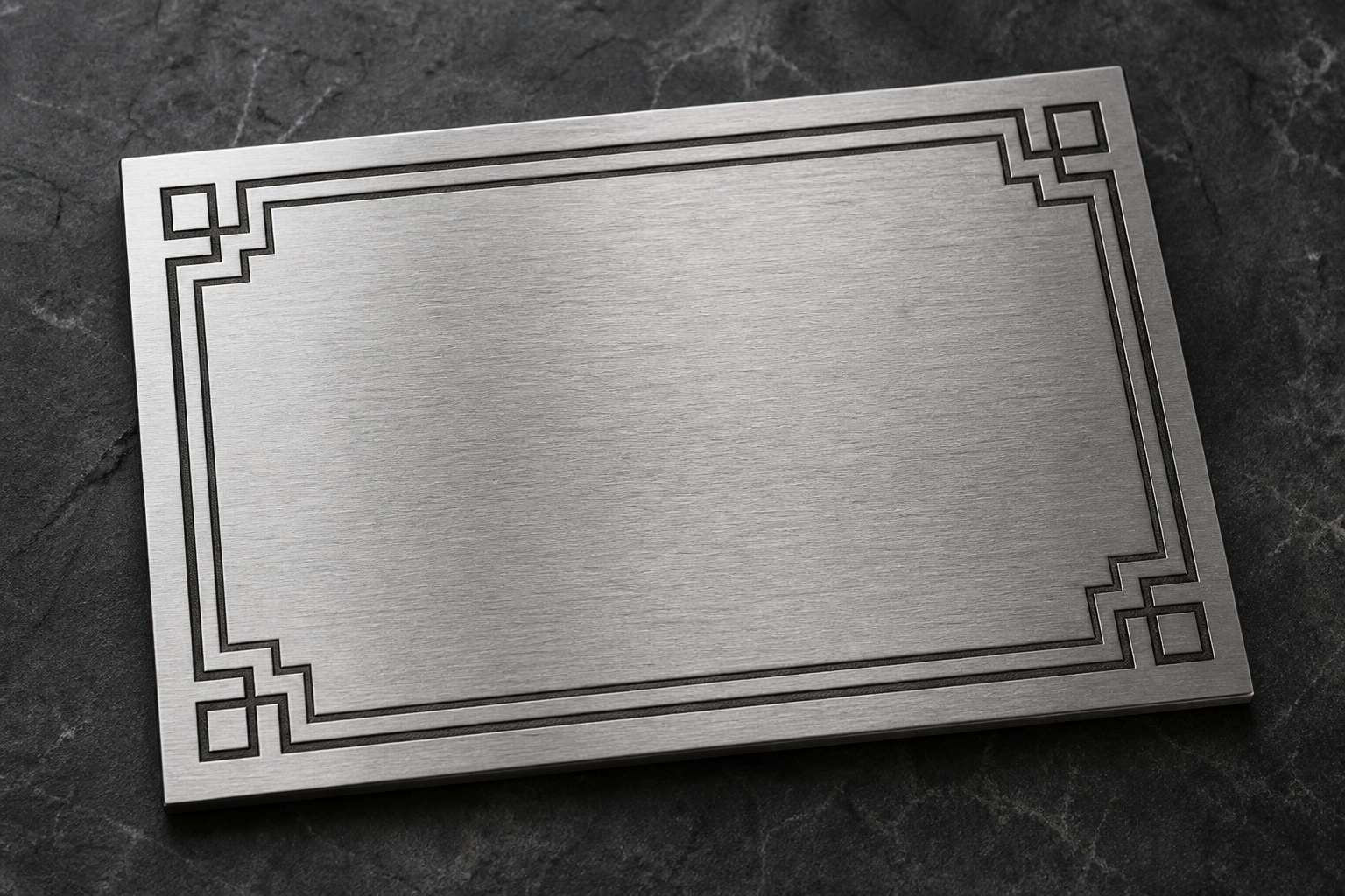 A brushed steel plaque with crisp laser-engraved geometric detailing